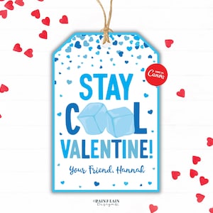 May include: A Valentine's Day gift tag with a blue border and the words "STAY COOL VALENTINE!" in blue. Two blue ice cubes are in the center. The tag is decorated with blue hearts and the text "Your Friend, Hannah".