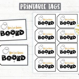 May include: Printable Halloween gift tags featuring a ghost with the text "You've been Booed" in black and orange lettering. The tags are designed to be printed and used for Halloween gift giving.