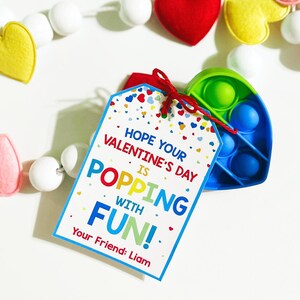 Puede incluir: Una tarjeta colorida de San Valent&iacute;n con un juguete pop-it adjunto. La tarjeta dice "Espero que tu d&iacute;a de San Valent&iacute;n sea explosivo de diversi&oacute;n!" y est&aacute; firmada "Tu amigo: Liam".