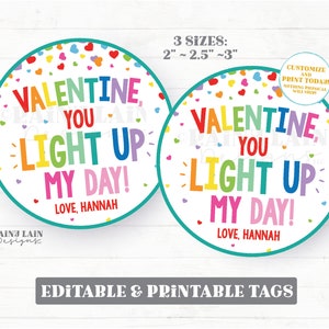 May include: Two round Valentine's Day printable tags with a rainbow coloured text that says "Valentine, You Light Up My Day!" with a heart confetti background. The tags are 2 inches, 2.5 inches, and 3 inches in diameter. The text "Love, Hannah" is at the bottom of the tags.