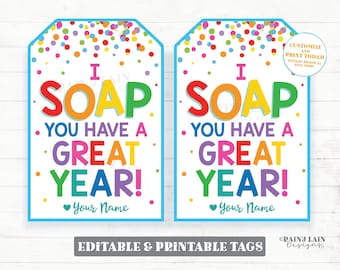 May include: Two printable gift tags with a colorful confetti background. The tags feature the text "I SOAP YOU HAVE A GREAT YEAR!" with the word "SOAP" in rainbow colors. The text "Your Name" is included at the bottom of each tag.