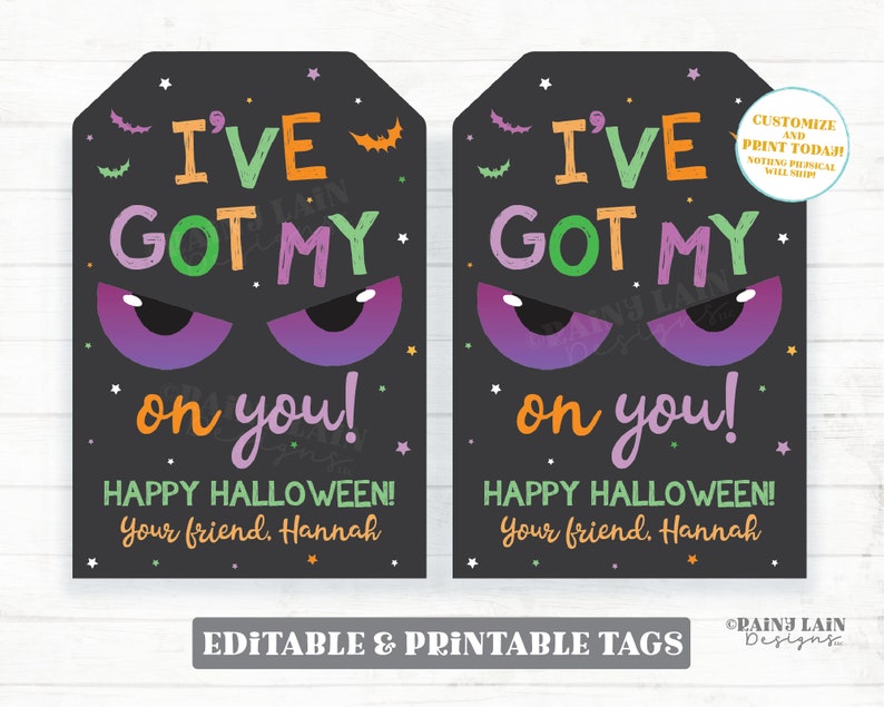 May include: Two printable Halloween gift tags with a black background and colorful text that reads "I've got my on you! Happy Halloween! Your friend, Hannah". The tags feature a pair of purple eyes with black pupils and a few stars.