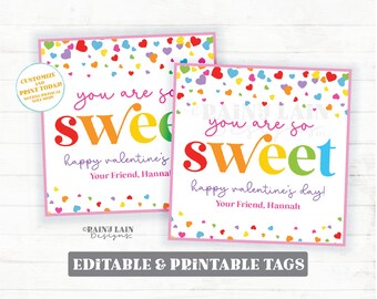 Op de afbeelding: Twee printbare Valentijnsdag-cadeauetiketten met een regenboog-bericht "je bent zo lief" en een achtergrond met hartjesconfetti. De etiketten zijn aanpasbaar en bewerkbaar.