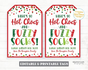 May include: Two printable gift tags with a red and green polka dot background. The tags say "Here's to Hot Chocs and Fuzzy Socks!" with warm wishes for 2022. The tags are editable and printable.