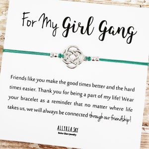 May include: A green friendship bracelet with a silver Celtic knot charm. The card reads "For My Girl Gang" and includes a message about friendship.