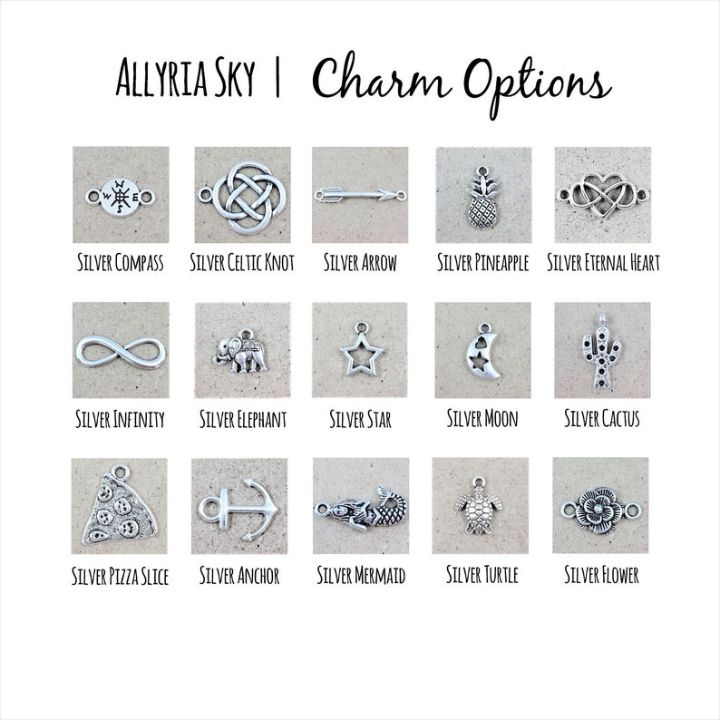 Puede incluir: Una cuadr&iacute;cula de 15 dijes de plata, cada uno representando un dise&ntilde;o diferente. Los dijes est&aacute;n dispuestos en tres filas de cinco. Los dijes incluyen una br&uacute;jula, un nudo celta, una flecha, una pi&ntilde;a, un s&iacute;mbolo de infinito, un elefante, una estrella, una luna, un cactus, una rebanada de pizza, un ancla, una sirena, una tortuga y una flor.