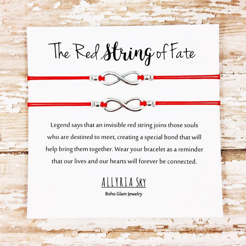 May include: Two red string bracelets with silver infinity charms. The card reads "The Red String of Fate" and includes a quote about the legend of the red string of fate. The card is signed "ALLYRIA SKY Boho Glam Jewelry".
