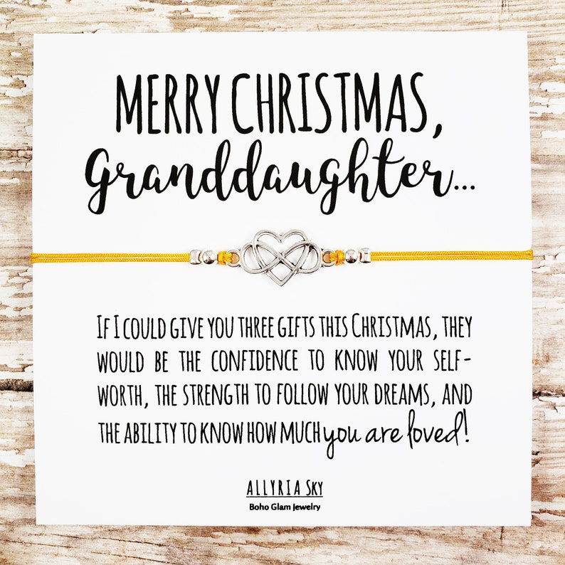 May include: A yellow string bracelet with a silver heart charm and the message "Merry Christmas, Granddaughter... If I could give you three gifts this Christmas, they would be the confidence to know your self-worth, the strength to follow your dreams, and the ability to know how much you are loved!"  Allyria Sky Boho Glam Jewelry