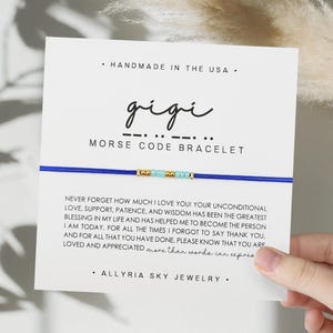 May include: A blue and white beaded bracelet with a card that says "gigi - .. - .. - MORSE CODE BRACELET" and a message about love, support, patience, and wisdom. The card also says "ALLYRIA SKY JEWELRY".