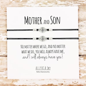 May include: A white card with black text that reads "Mother and Son" and "No matter where we go, and no matter what we do, you will always have me, and I will always have you!"  The card also includes the text "ALLYRIA SKY" and "Boho Glam Jewelry". Two black bracelets with compass charms are displayed on the card.