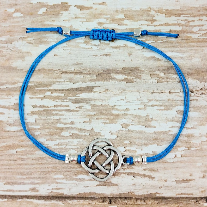 Puede incluir: Un brazalete de cord&oacute;n azul con un dije de nudo celta plateado y cuentas plateadas.