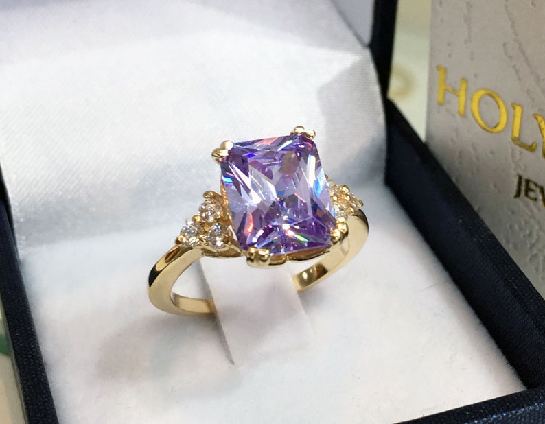 An absolute stunner, classic lavender amethyst engagement ring with an emerald cut gemstone of your choice as it’s centre stone and with round cut clear quartz on the band to further accentuate it.