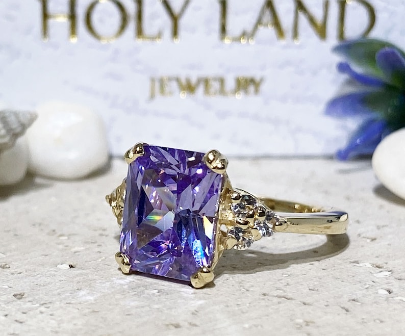 An absolute stunner, classic lavender amethyst engagement ring with an emerald cut gemstone of your choice as it’s centre stone and with round cut clear quartz on the band to further accentuate it.