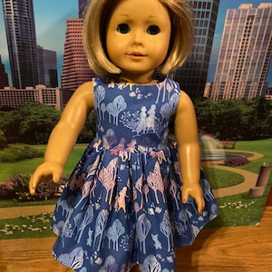 May include: A blue dress with a white and pink floral pattern featuring characters from the film Frozen. The dress is sleeveless and has a gathered skirt.