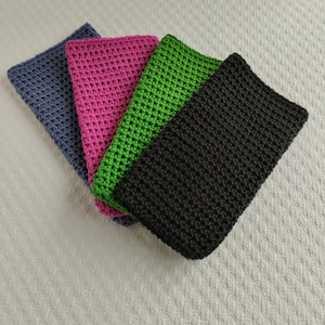 Puede incluir: Cuatro fundas de teléfono de ganchillo en diferentes colores: gris, rosa, verde y negro.