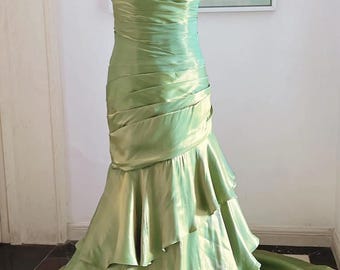 May include: A green satin mermaid-style gown with a ruffled skirt and a strapless bodice.