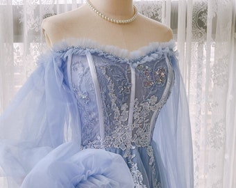 May include: A light blue off-the-shoulder gown with a lace bodice and tulle sleeves. The bodice is decorated with sequins and beading.