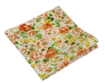 May include: A white fabric handkerchief with a floral pattern featuring orange, yellow, and green flowers.