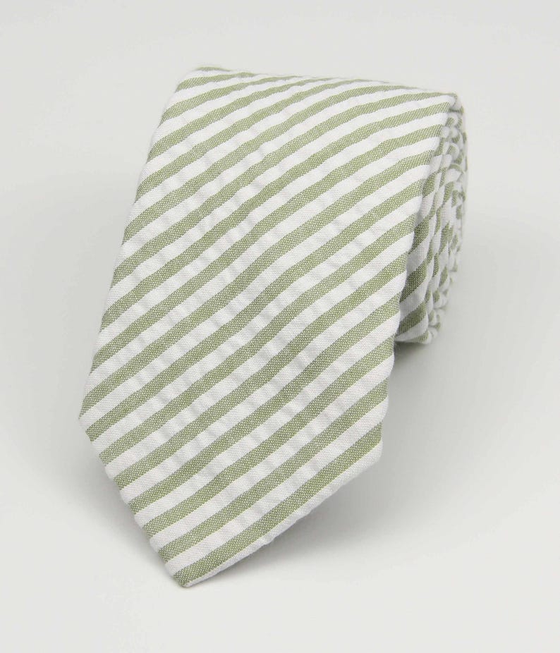 May include: A green and white striped tie. The tie is made of a soft, textured fabric.