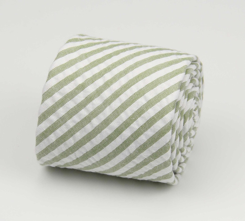 May include: A rolled up green and white striped fabric tie.