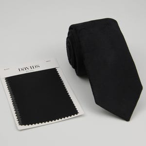 May include: A black necktie with a fabric swatch showing the colour and texture. The swatch is labelled "David's Bridal" and "Black".