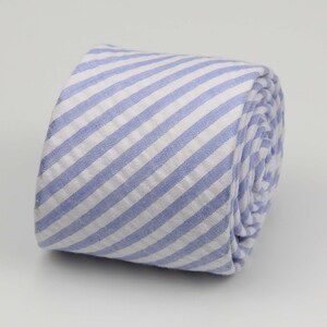 May include: A blue and white striped tie rolled up. The stripes are diagonal.
