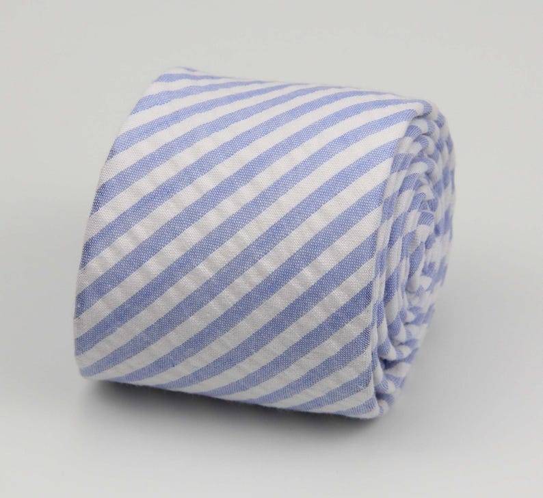 May include: A blue and white striped tie rolled up. The stripes are diagonal.