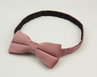 May include: A dusty rose velvet bow tie with an adjustable black strap.