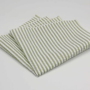 May include: A folded green and white striped linen handkerchief.