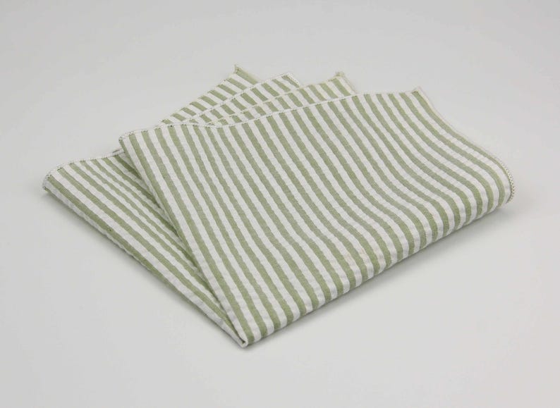 May include: A folded green and white striped linen handkerchief.