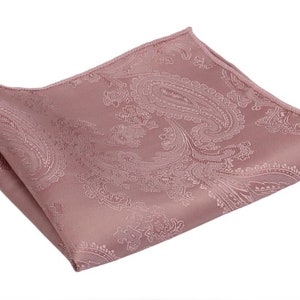 Può includere: Un fazzoletto da taschino rosa con motivo paisley. Il fazzoletto è piegato e ha una leggera lucentezza.