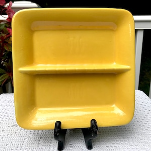 May include: A yellow ceramic divided serving dish with a glossy finish. The dish has two sections separated by a raised divider.