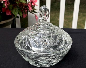 May include: A clear glass candy dish with a starburst pattern and a knobbed lid.