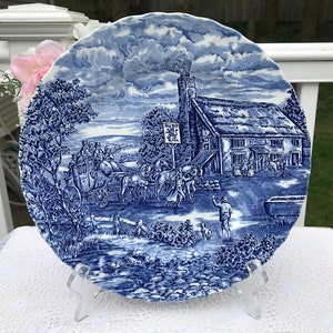 May include: Blue and white ceramic dinner plate with a scene of a horse-drawn carriage traveling past a pub called "The Red Lion".