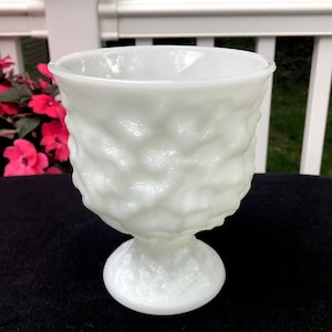 Puede incluir: Jarrón de vidrio de leche blanco con un diseño texturizado con forma de burbujas. El jarrón tiene un cuenco ancho y redondo y un tallo corto y robusto.