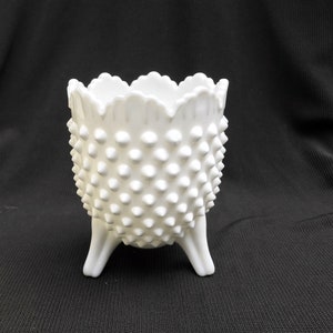 May include: White milk glass planter with a scalloped rim and a textured, dotted surface. The planter has three legs and is perfect for displaying small plants or flowers.