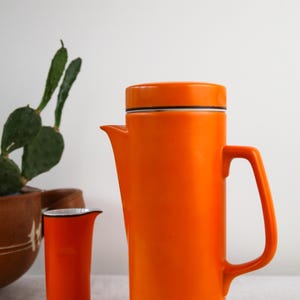 MCM orange porcelain coffee pot, sugar bowl and cream decanter by Schmid