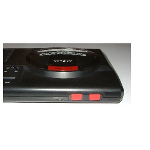 May include: A black Sega Genesis console with a silver top and two red buttons on the front.