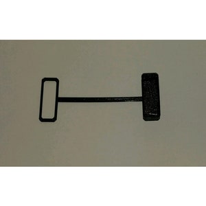 May include: A black plastic toggle switch with a rectangular shape. The switch is in the off position.