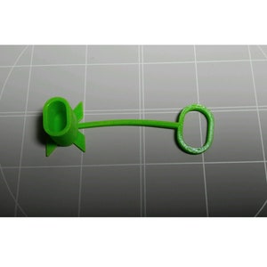 May include: A green plastic cable tie with a loop on one end and a plug on the other end.