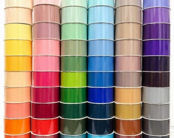 Puede incluir: Una colección de seis pilas verticales de carretes de cinta dispuestos en un espectro de colores. Cada pila contiene múltiples carretes individuales de cinta de color sólido, que van desde el blanco, amarillo y naranja hasta el rosa, verde, azul y negro.