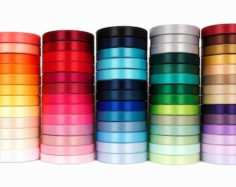 May include: Five vertical stacks of satin ribbon spools arranged in a spectrum of colors. The stacks include shades of red, orange, yellow, pink, blue, green, purple, and neutral tones. Each spool is circular with a smooth, reflective finish.