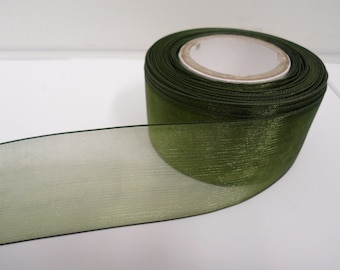 May include: A roll of green sheer ribbon with a satin finish. The ribbon is rolled up and the end is hanging down.