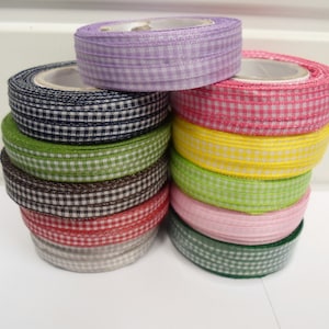 Può includere: Un set di 10 rotoli di nastro gingham in vari colori, tra cui rosa, giallo, verde, marrone e blu.