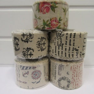 Peut inclure: Un rouleau de ruban de toile de jute avec quatre motifs différents. Le rouleau du haut présente un motif floral avec des fleurs roses et vertes. Le deuxième rouleau a un motif noir et blanc avec un motif de croix. Le troisième rouleau a un motif noir et blanc avec un motif de texte. Le rouleau du bas a un motif noir et blanc avec un motif nautique.