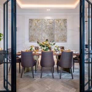 Textured triptych artwork in shades of  beige and gold, hangs on the wall of a dinengroom. Proudly highligting the wall above a dining table and chairs.