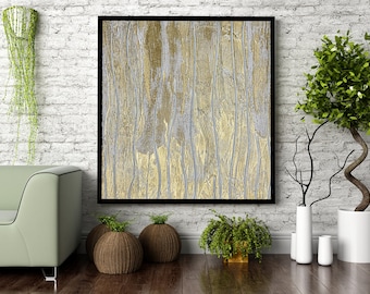 May include: A framed abstract painting with vertical lines in shades of gold and silver hangs on a white brick wall. The painting is surrounded by plants and a green sofa.