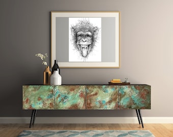 May include: A black and white line art drawing of a monkey with its mouth open and tongue sticking out. The drawing is framed and hanging on a gray wall above a rustic-looking wooden cabinet with three drawers.