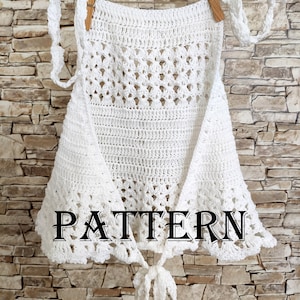 May include: A white, crocheted top with a decorative openwork design, hanging from a clothesline with wooden clothespins. The word "PATTERN" is printed across the bottom of the top.