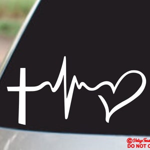 Puede incluir: Calcomanía de vinilo blanco con una cruz, una línea de latido cardíaco y una forma de corazón. El diseño es una representación minimalista de la fe y el amor, adecuada para ventanas de automóviles u otras superficies.